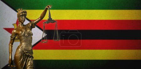 Nahaufnahme einer kleinen Bronzestatuette der Lady Justice vor einer Flagge Simbabwes.