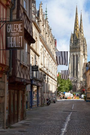 Téléchargez les photos : Quimper, France - 24 juillet 2017 : Rue médiévale étroite décorée de drapeaux bretons (Gwenn-ha-du) se dirigeant vers la cathédrale Saint Corentin de Quimper. - en image libre de droit