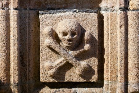 Crâne et os sculptés sur l'ossuaire de l'église Saint-Yves de La Roche-Maurice.