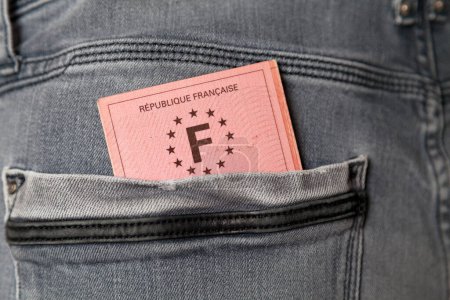 Gros plan sur un permis de conduire français dans la poche arrière d'un jean.