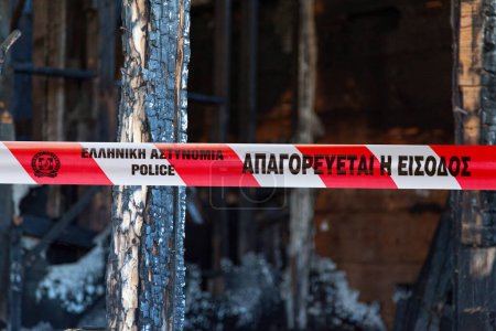 Téléchargez les photos : Athènes, Grèce - 23 juin 2017 : Une maison incendiée par un pyromane avec une cassette de police écrite en grec. - en image libre de droit