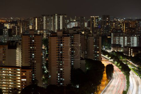 Luftaufnahme der Mautstraße durch die Eigentumswohnungen in Novena, Singapur bei Nacht.