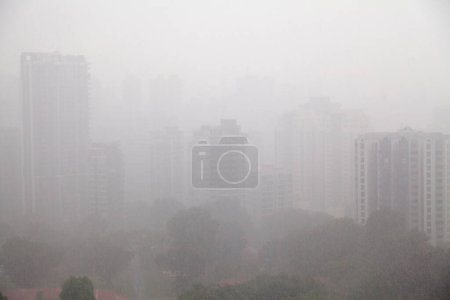 Luftaufnahme der Eigentumswohnungen in Novena (Singapur) bei starkem Regen, der sie kaum sichtbar macht.