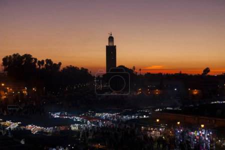 Téléchargez les photos : Marrakech, Maroc - 28 janvier 2019 : Jemaa el-Fnaa au coucher du soleil avec la mosquée Koutoubia derrière. - en image libre de droit