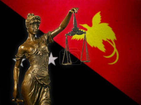 Nahaufnahme einer kleinen Bronzestatuette der Lady Justice vor einer Flagge Papua-Neuguineas.