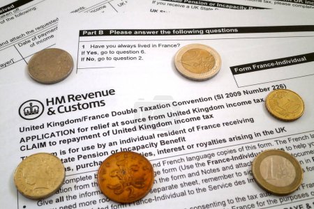 Photo for United Kingdom/France Double Taxation Convention with some coins from both countries. - Royalty Free Image