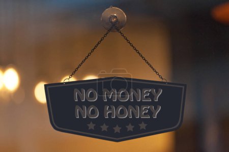 Sign in a window with written in it "No money No honey".