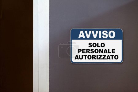 Blau-weißes Hinweisschild an der Seite einer geöffneten Tür, auf Italienisch: "Avviso, Solo personale autorizzato", was "Hinweis, nur autorisiertes Personal" bedeutet".