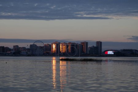 Spiegelung des Sonnenuntergangs auf der gegenüberliegenden Seite des Flusses an den Wohngebäuden neben der Arena und dem Aquapark in Kasan.