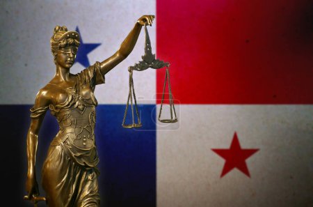 Nahaufnahme einer kleinen Bronzestatuette der Lady Justice vor einer Flagge Panamas.