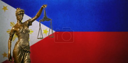 Gros plan d'une petite statuette en bronze de Lady Justice devant un drapeau des Philippines.