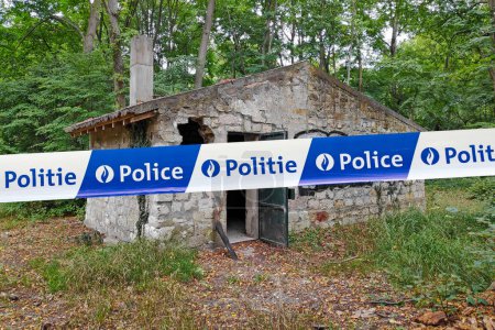 Téléchargez les photos : Bruxelles, Belgique - 23 juin 2017 : Maison en pierre abandonnée dans les bois avec une cassette de police avec écrit en français "Police" et néerlandais "Politie". - en image libre de droit