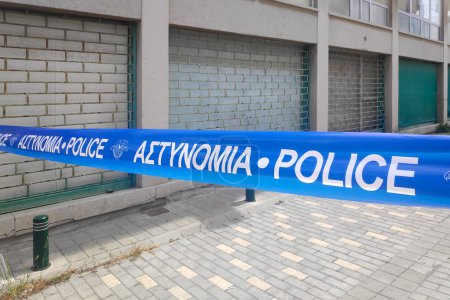 Téléchargez les photos : Larnaca, Chypre - 07 avril 2024 : Rue fermée avec une cassette de police écrite en grec et en anglais. - en image libre de droit