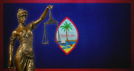 Nahaufnahme einer kleinen Bronzestatuette der Lady Justice vor einer Flagge von Guam.