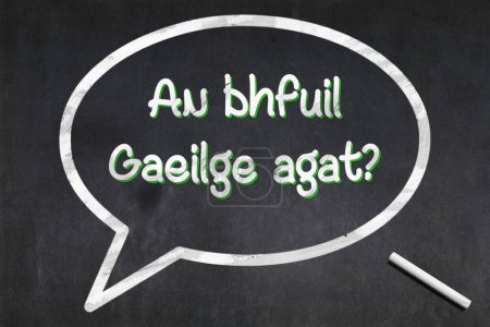 Blackboard with a bubble drawn in the middle with the short phrase in Irish "An bhfuil Gaeilge agat?", meaning "Do you speak Irish ?".