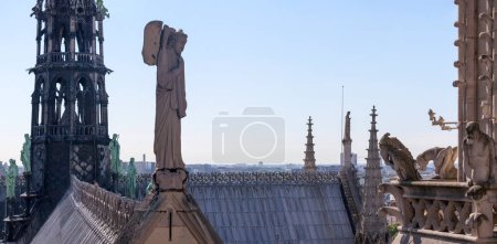 Panoramic view of the roof of Notre Dame De Paris with its spire, Gargoyles and statues. 