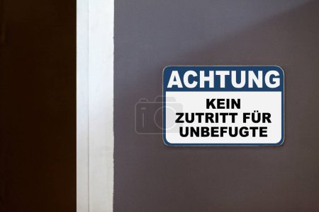 Blau-weißes Hinweisschild an der Seite einer offenen Tür mit der Aufschrift: "ACHTUNG, KEIN ZUTRITT FUR UNBEFUGTE", was "Hinweis, Kein Zutritt für Unbefugte" bedeutet.".