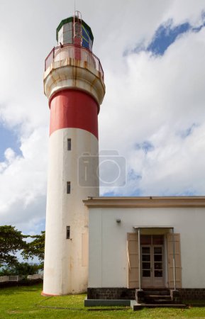 Lighthouse of Sainte-Suzanne on the top of the cliff with the flag of Reunion Island.
