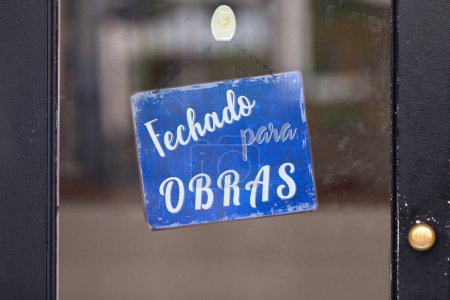 Blue open sign with written in Portuguese "Fechado para obras" meaning in English "Closed for holidays".