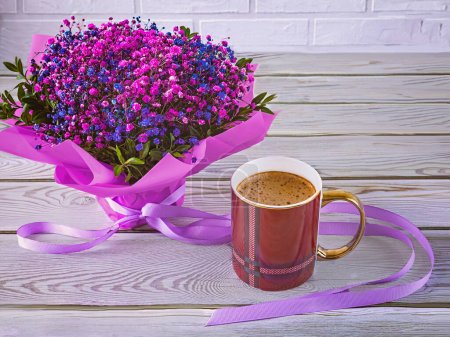 Téléchargez les photos : Un bouquet de fleurs de gypsophile, une coupe viva-magenta. Nature morte festive aux couleurs violettes sur un fond en bois et en brique. - en image libre de droit