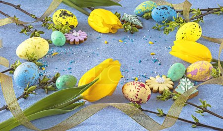 Foto de Fondo de Pascua con huevos pintados, flores de tulipán, cinta amarilla sobre fondo azul. Composición festiva de primavera - Imagen libre de derechos