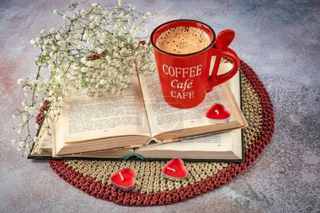 Foto de Bodegón con una taza de café rojo con una cuchara, libros, flores de gypsophila y velas. Vista desde arriba - Imagen libre de derechos