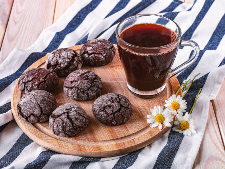 Foto de Galletas de chocolate recién horneadas en una bandeja y una taza de café negro en la mesa, vista superior - Imagen libre de derechos