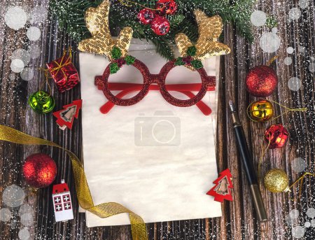 Foto de Composición de Navidad y Año Nuevo con hoja de papel artesanal y decoración navideña, guirnalda dorada, gafas de Año Nuevo. Lugar para la prueba, vista superior - Imagen libre de derechos