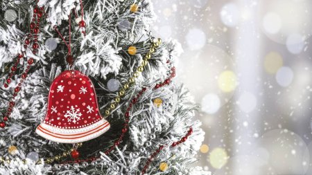 Foto de Juguete rojo del árbol de Navidad del vidrio en forma de campana en un árbol de Navidad nevado. Tarjeta de Navidad con bokeh - Imagen libre de derechos