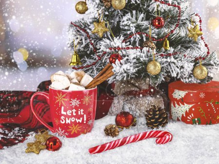 Photo for Red cup of cocoa with marshmallows, snowy Christmas tree, Christmas lollipop, woolen scarf and Christmas decorations. Winter composition let it snow. - Royalty Free Image