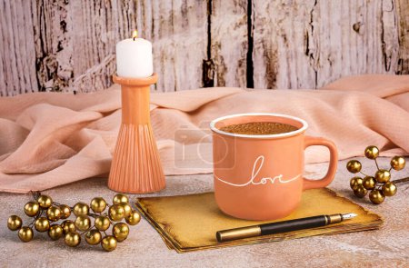 Foto de Bodegón romántico en el color del año 2024 Peach Fuzz. Una taza de café melocotón, un pedazo de tela de color melocotón, hojas de papel artesanales, un bolígrafo, una vela ardiente - Imagen libre de derechos