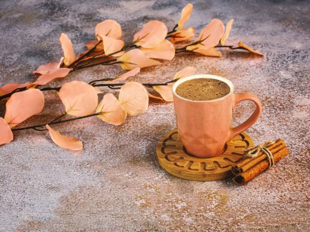 Foto de Bodegón en el color del año 2024 Melocotón Fuzz. Melocotón taza de café, rama de flores, canela sobre fondo de hormigón. - Imagen libre de derechos