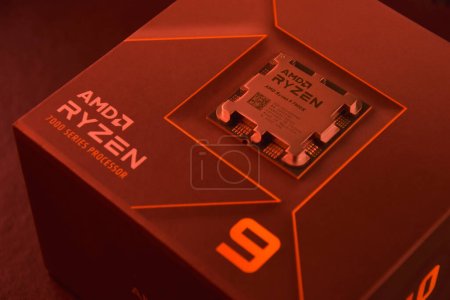 Photo for UKRAINE, KHARKIV, NOVEMBER 14, 2022: A close-up of an AMD Ryzen 9 3900X processor in a packaging box with backlit keyboards in the background. - Royalty Free Image