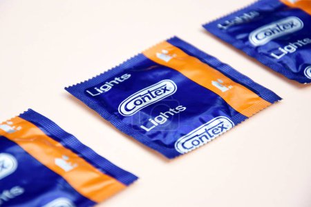 Foto de KHARKIV, UCRANIA - 16 DE OCTUBRE DE 2021: Condón de condón sobre fondo de marfil. Contex es una marca de condones y lubricantes personales propiedad de Reckitt Benckiser. Concepto de protección sexual. - Imagen libre de derechos