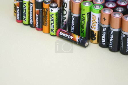 Photo for KHARKIV, UKRAINE - JUNE 11, 2022: Used AA batteries and proper disposal of environmentally and soil toxic batteries on a green background. The concept of processing harmful and recyclable objects. - Royalty Free Image