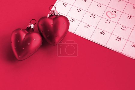 Téléchargez les photos : Two red hearts and calendar marked February 14, concept of Valentine's, anniversary. Image toned in Viva Magenta, color of the 2023 year. - en image libre de droit