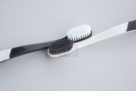 Photo for Toothbrushes with a small figure of a tooth on a light background. Dental health concept. - Royalty Free Image