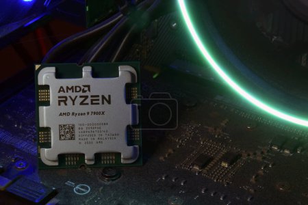 Foto de UCRANIA, KHARKIV, 14 DE NOVIEMBRE DE 2022: Primer plano de un procesador AMD Ryzen 9 7900X, en el contexto de los refrigeradores con luz. - Imagen libre de derechos