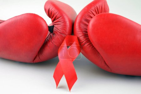Photo for Red ribbon with boxing gloves, wrestling symbol. World AIDS Day and National HIV, AIDS and Aging Awareness Month. - Royalty Free Image