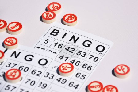 Foto de Muchas fichas de madera con números y tarjetas para un juego de mesa de bingo o lotería sobre un fondo claro. Lotto ruso tiene reglas similares al clásico juego de bingo mundial. - Imagen libre de derechos
