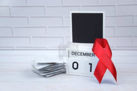 Foto de Cinta roja con calendario, símbolo de lucha. El 1 de diciembre es el Día Mundial del Sida y el Mes Nacional del VIH, el SIDA y el Envejecimiento. - Imagen libre de derechos