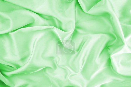 Green chiffon fabric texture for background. Silk fabric. Selective focus.