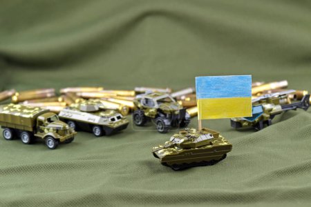 A battle tank with the Ukraine flag on a background of US dollar banknotes. The concept of military assistance.