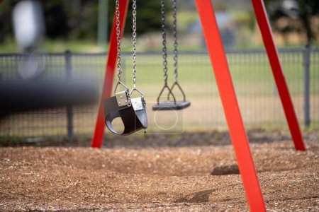 Photo for Slides and swings in a playground in a park in australia in spring - Royalty Free Image