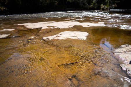 red rocks in a stream iof tannin water in australia