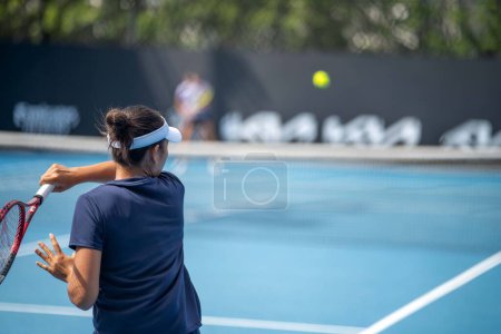 Téléchargez les photos : Amateur playing tennis at a tournament and match on grass in Melbourne, Australia in summer - en image libre de droit