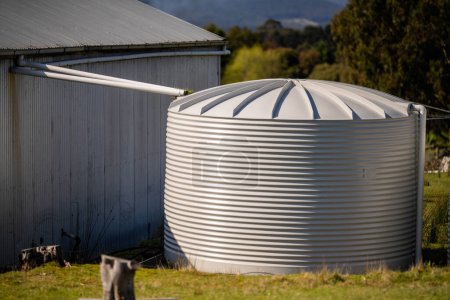 tanque de agua de lluvia frente a una casa en Australia en el arbusto