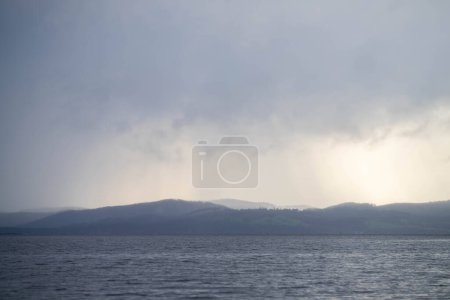 Téléchargez les photos : Rayons à travers les nuages sur l'eau - en image libre de droit
