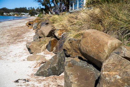 Photo for Beach rock wall on a sandy beach in australia. ocean wall - Royalty Free Image