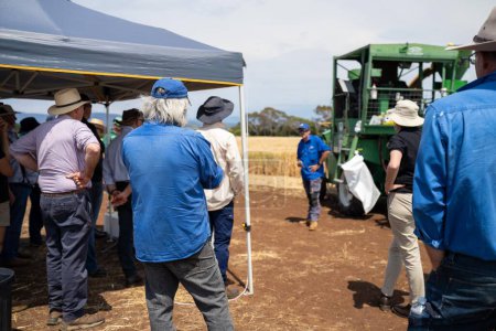 Téléchargez les photos : Groupe d'agriculteurs effectuant une promenade agricole en apprenant sur la santé et l'agronomie des cultures par un agronome agricole des essais de blé et d'orge en Australie - en image libre de droit